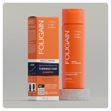 TRIOXIDIL 2%配合のFOLIGAIN男性用トリプルアクションシャンプー、オレンジ色のボトルと箱。