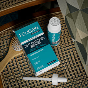 ヘアブラシの横にあるFOLIGAIN DHTセラムの箱、ボトル、スポイトを真上から見た様子。