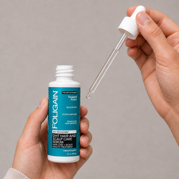 開封したFOLIGAIN DHTヘア＆スカルプケアセラムのボトルと、セラムの入ったスポイトを持つ両手。